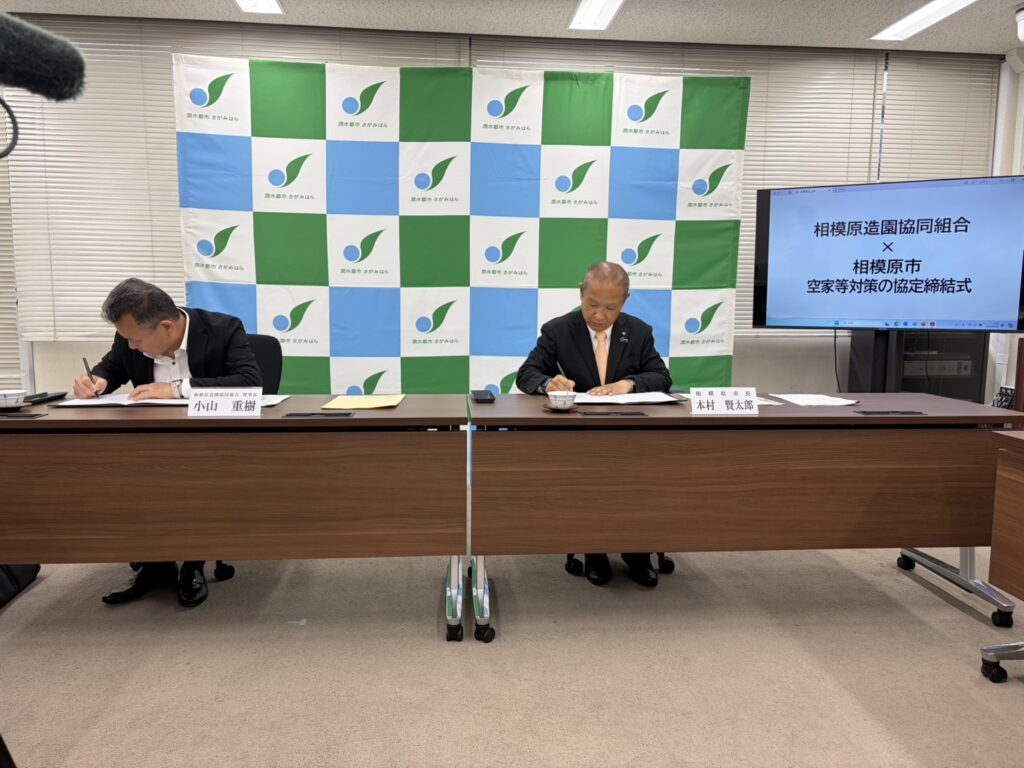空家等対策の協定締結式でサインをする相模原市長と理事長